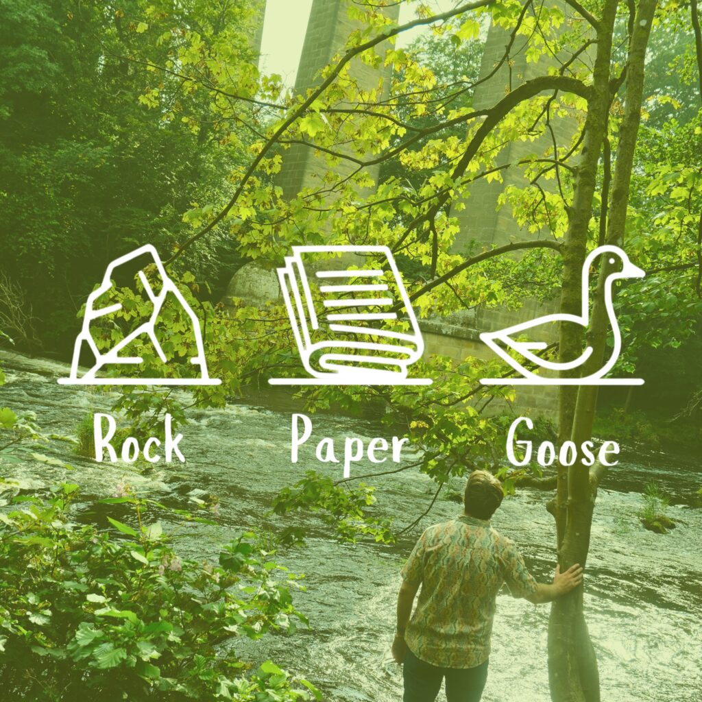 Rock Paper Goose icons and text "Rock Paper Goose" over the top of an image of Nathan looking out over a river underneath a bright and leafy canopy